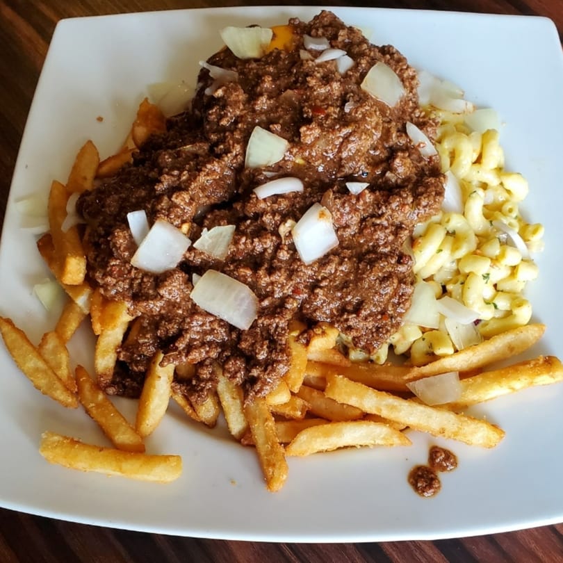 A plate of Elmwood Inn's chili cheese fries with macaroni and cheese, topped with diced onions.